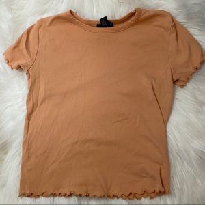 A sherbet orange colored short sleeve shirt
